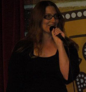 Public Speaker and Meditation Teacher, Sindi Somers with microphone.